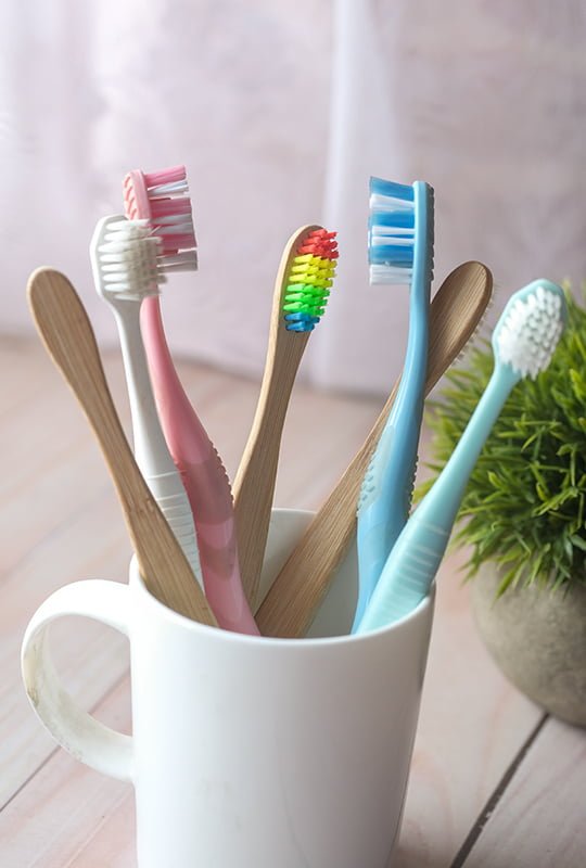 Verschiedenfarbige Zahnbürsten aus Holz Kunststoff in Becher