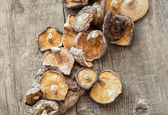 Getrocknete Shiitake-Pilze liegen auf einer hölzernen Unterlage