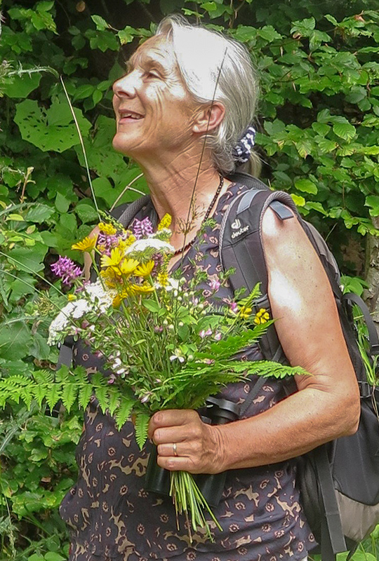 L'auteur Barbara Bichsel en robe d'été avec un bouquet de fleurs