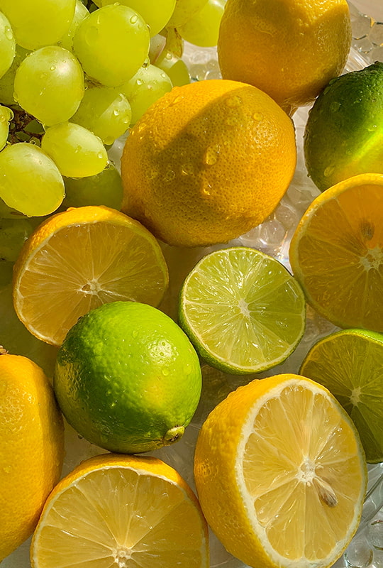 frische Zitronen und Limonen liegen auf Eiswürfeln