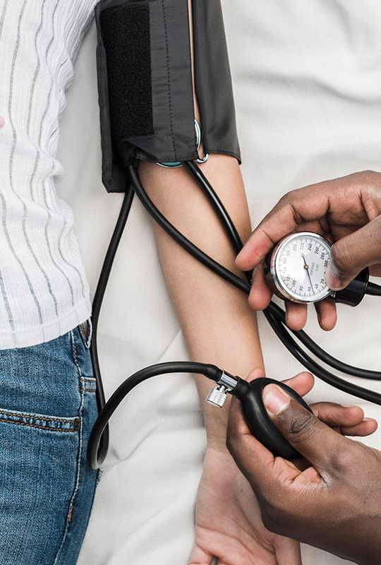 Medizinische Fachperson misst den Bluthochdruck an entblösstem Arm
