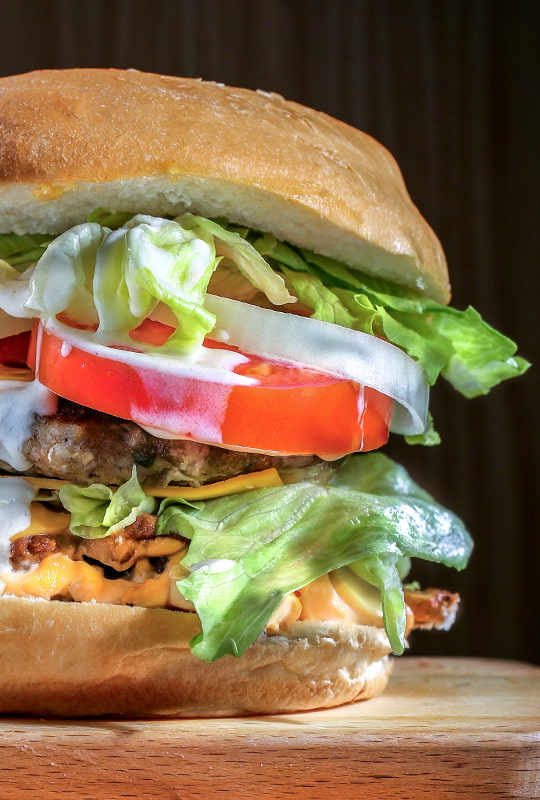 Hamburger mit Salat­blättern, Fleisch und Sauce