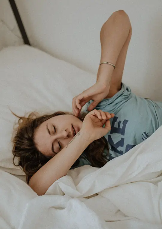 Eine im Bett liegende Frau schläft unruhig
