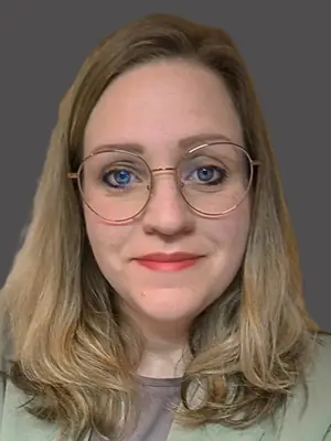 Eine dunkelblonde Frau mit Brille blickt in die Kamera